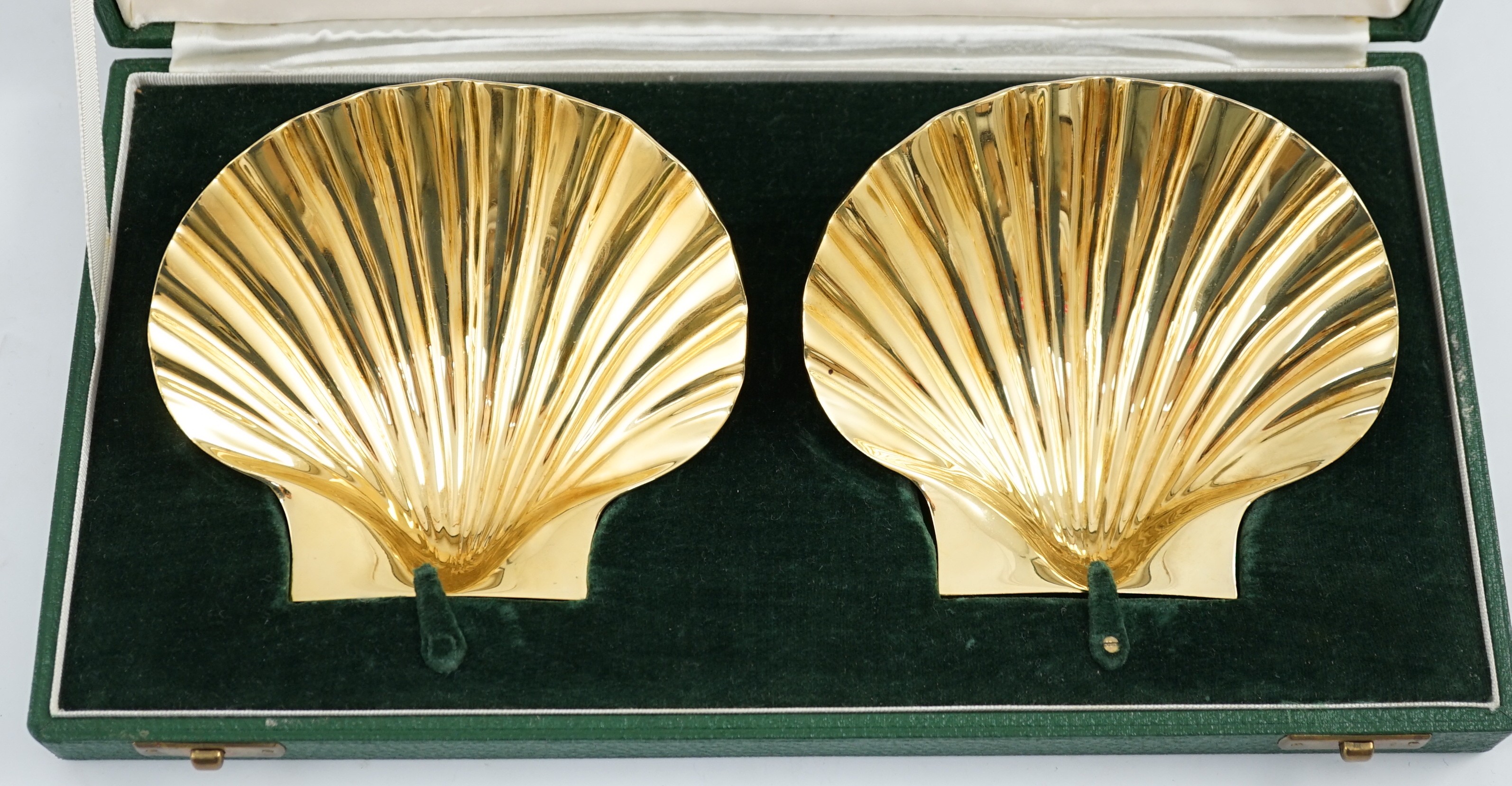 A cased pair of Elizabeth II silver gilt scallop shell butter dishes by Collingwood & Co